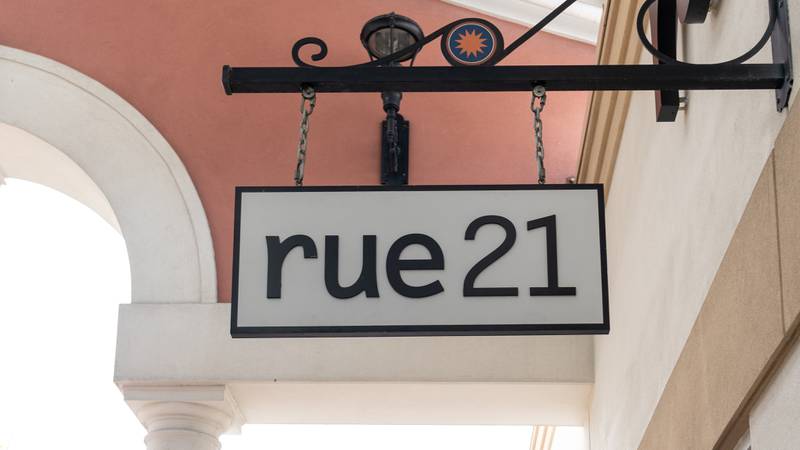 A rue21 sign hanging outside of a store.